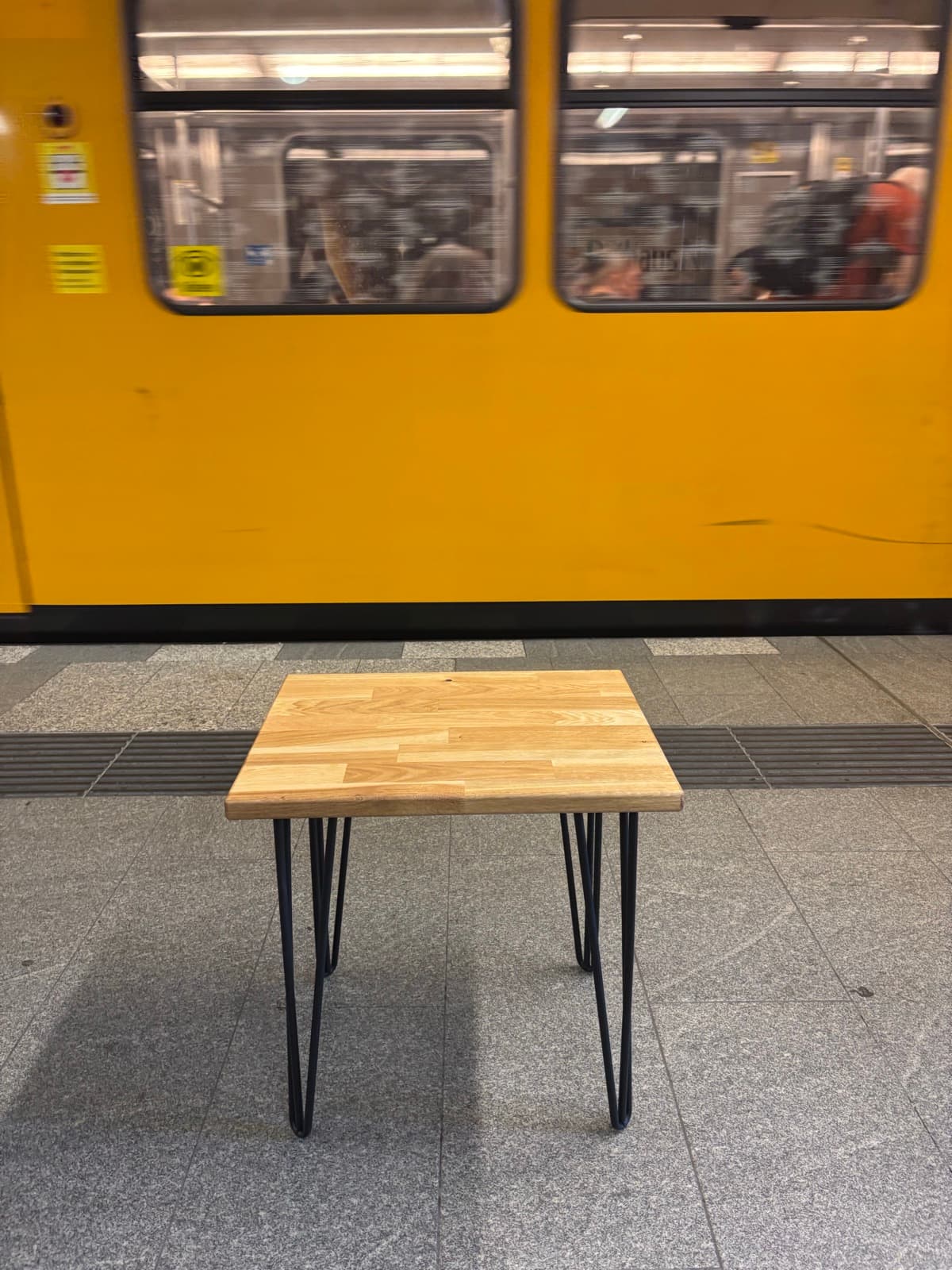 Der Standardtisch von vorn, vor einem gelben U-Bahn-Wagen